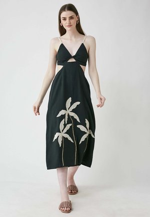Schwarzes Midi-Kleid mit Cut-out-Design, verstellbaren Trägern und besticktem Palmenblattmuster in Beige. Glattes Gewebe mit lockerer Passform.