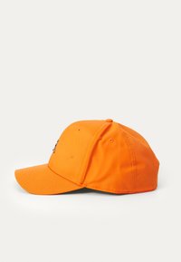 Orange baseball cap med en buet skygge, lavet af struktureret stof, med ventilationshuller og en justerbar rem bagpå.