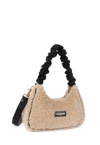 Faux fur handtas in een tan kleur met een pluche textuur. Voorzien van een zwart stoffen handvat en gouden hardware, ritsluiting en een logo-detail.