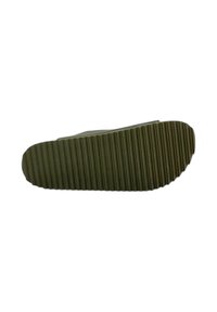 Suola in gomma verde con un motivo testurizzato e righe. Forma leggermente arrotondata sulla parte anteriore, posteriore piatta. Bordo liscio e design minimalista.