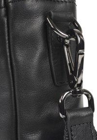 Schwarze Lederhandtasche mit strukturierten Oberflächen, silbernen Beschlägen und einem Clip-Verschluss für verstellbare Trageriemen.