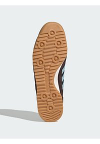 Μαύρο αθλητικό παπούτσι με σόλα από καουτσούκ, που διαθέτει υφή στην εξωτερική σόλα και ελαφρώς γαλάζιες λεπτομέρειες. Διακριτικό σχέδιο με τρεις ρίγες και καμπύλες άκρες.