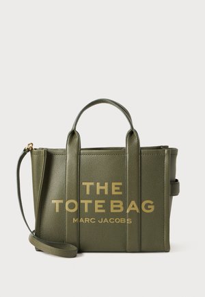 Geantă tote din piele verde măsliniu cu text auriu "THE TOTE BAG MART JACOBS", două mânere superioare și o curea de umăr detașabilă.