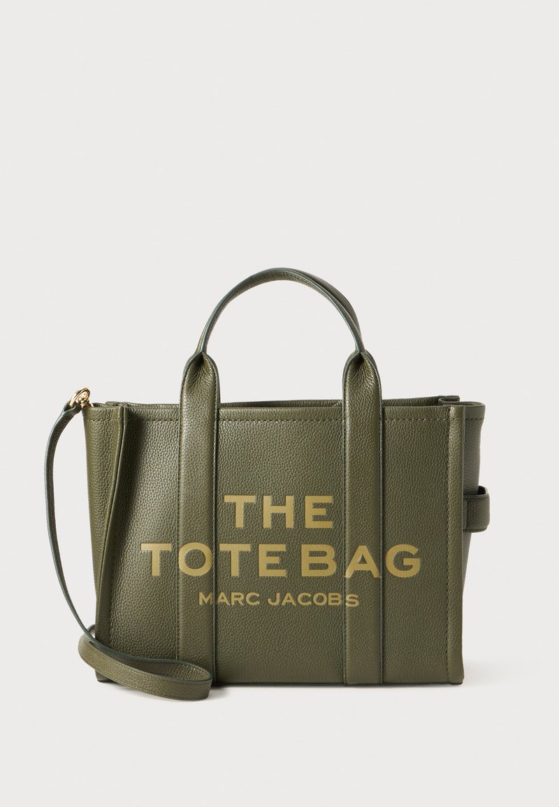 Olijfgroene leren schoudertas met gouden tekst "THE TOTE BAG MART JACOBS", twee bovenhandvaten en een afneembare schouderriem.