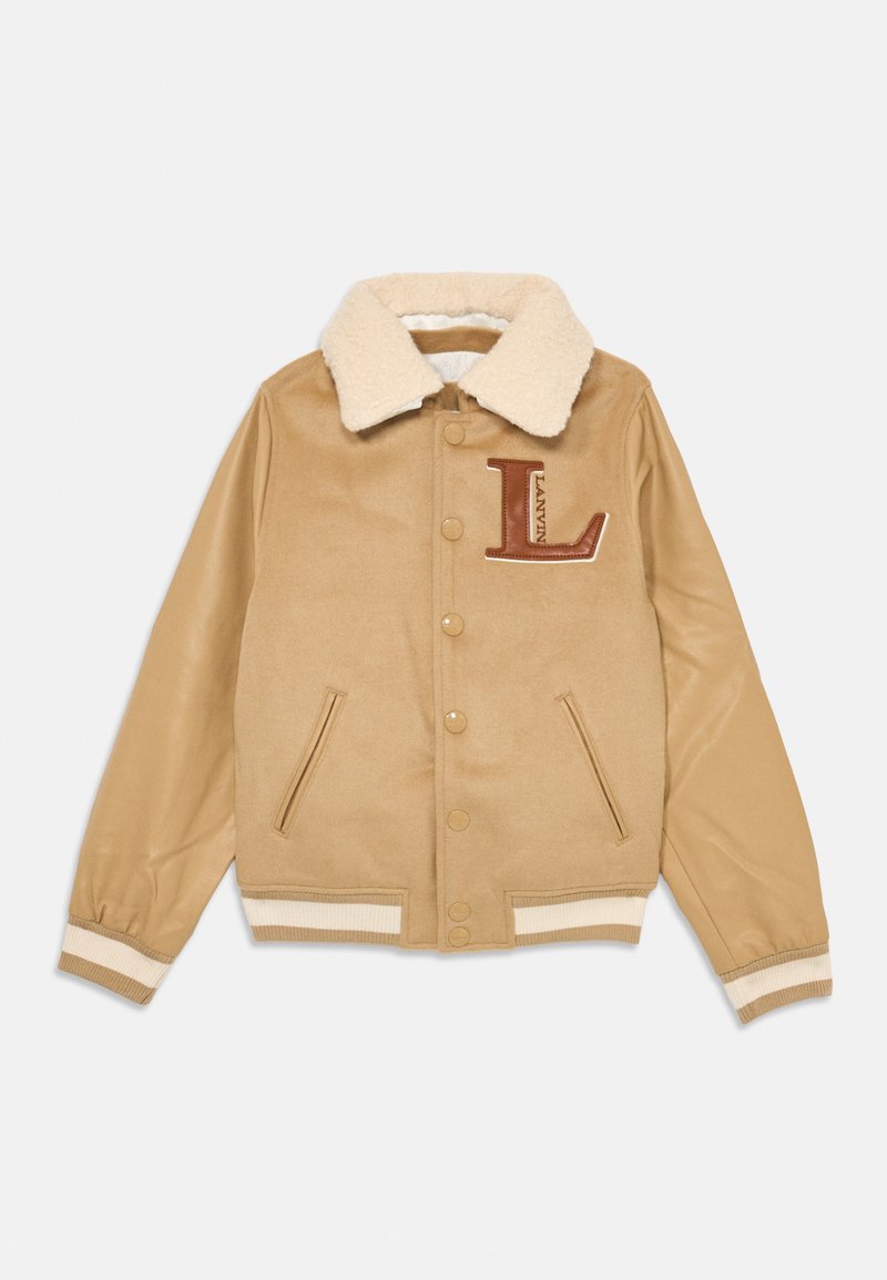Tan univerzitetna jakna s umetnim ovčjim krznom na ovratniku, usnjenimi rokavi, zapiranjem na snap gumbe in izvezenim logotipom "L" na prsih. Ima ribane manšete.