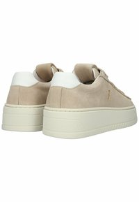 Poros smėlio spalvos zomšinių sportbačių su storomis balkšvomis gumos padais ir baltomis kulno apykaklėmis, matomos iš nugarinės ir pasvirusios šoninės pusės.