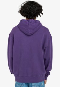 Sudadera de algodón morada con un corte relajado, mangas largas y capucha con cordón. Textura suave con puños y dobladillo acanalados.