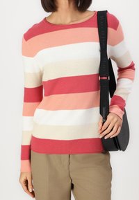 Pull à manches longues rayé dans des tons de rose, blanc et beige. Tissu en maille douce avec un col rond et des poignets ajustés.