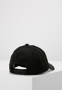 Casquette de baseball noire en tissu avec une couronne arrondie, un visière courbée et une sangle ajustable à l'arrière, arborant un logo en relief.