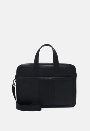 Mallette en cuir noir avec double poignée, bandoulière réglable, panneau central texturé et petit logo Tommy Hilfiger sur la poche avant.