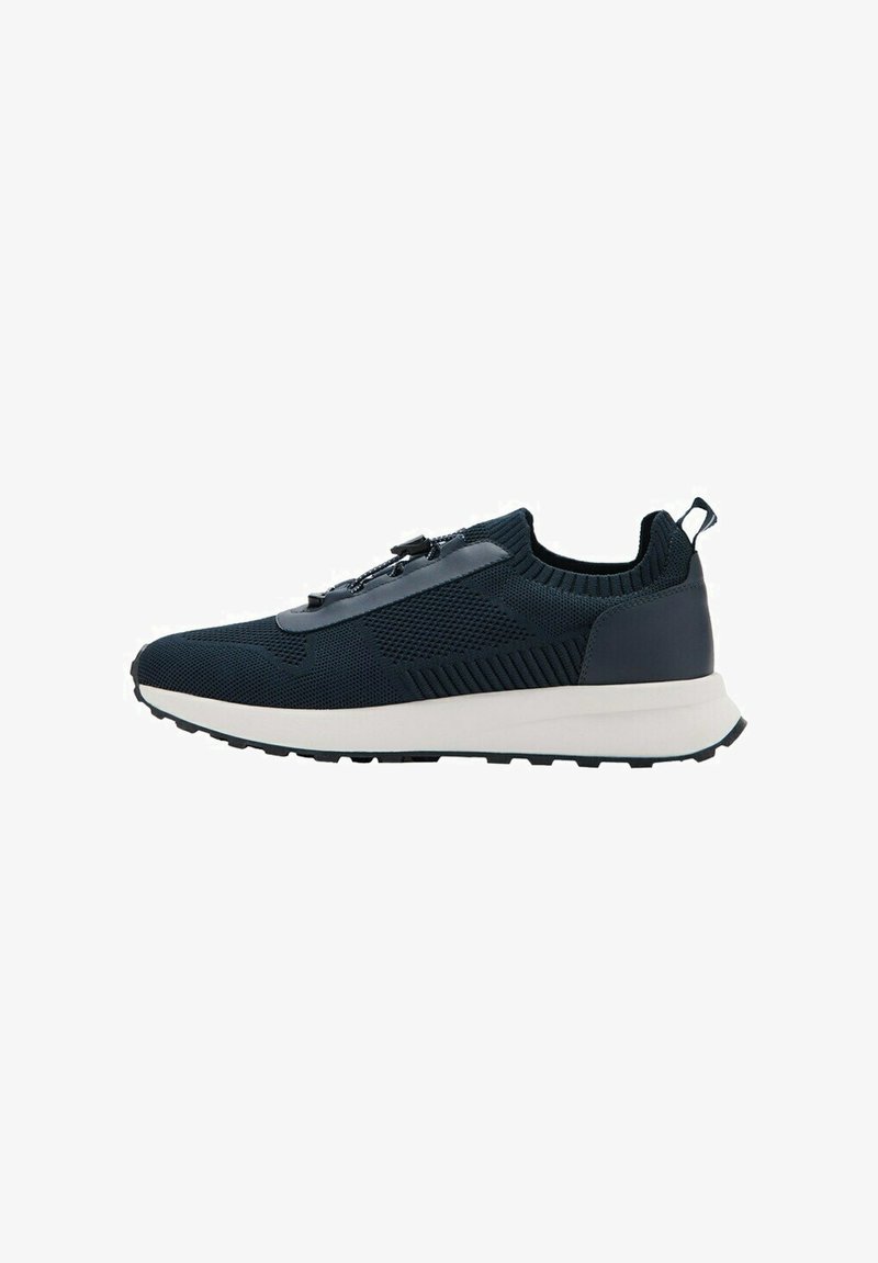 Basket basse en mesh noir avec semelle blanche, col élastique et système de laçage à bascule, vue de profil sur fond blanc.