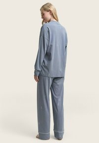 Blauw en wit gestreepte pyjama's met een relaxed fit, lange mouwen en een elastische tailleband. Kenmerkt zich door een subtiel patroon en omgeslagen enkelmanchetten.