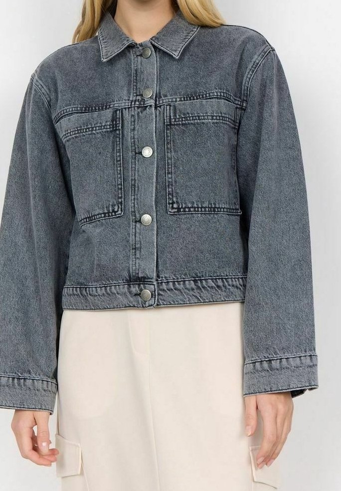 Giacca di jeans nera scolorita, con colletto, chiusura frontale con bottoni, due tasche sul petto e maniche ampie. Tessuto testurizzato con dettagli di cucitura visibili.