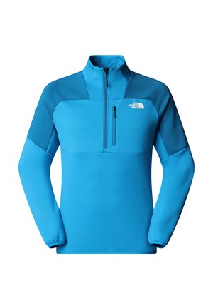 Blå fleece pullover med høj krave, halv lynlås foran og kontrasterende mørkere skulderpaneler. Har en lynlåslomme på brystet.