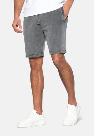 Shorts en denim gris avec une coupe décontractée, cinq poches et un léger effet usé. Associés à des baskets blanches pour un look décontracté.