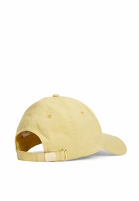 Gul stof baseball cap med buet skygge, justerbar rem og metalspænde bagpå. Glat tekstur og enkelt design.