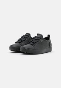 Schwarze Sneakers mit einem Obermaterial aus glattem Leder, runder Spitze, flacher Gummisohle und Schnürdesign mit runden Schnürsenkeln sowie einer Zuglasche an der Ferse.