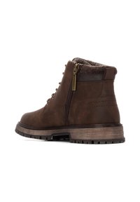 Botas de tobillo de cuero marrón con un cuello forrado de piel texturizada, cremallera lateral y suela de goma resistente; presenta ojales de metal y cordones.