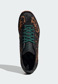 Mustat ja ruskeat leopardi-kuosisneakerit, joissa on teksturoitu päällinen, vihreät nauhat ja tyylikäs kumipohja, jossa on brändin logo sisäpuolella.