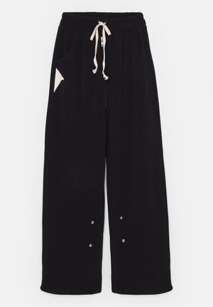Mustad laiad püksid pehmest kangast, millega kaasneb paelaga vöökoht, küljetaskud ja kolmnurkne aksenttasku. Hõbedased detailid on lisatud.