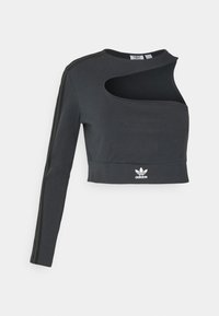 Czarny krótki top z długim rękawem o unikalnym kroju z wycięciami i szarymi paseczkami. Posiada białe logo Adidas na dolnym brzegu.