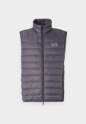 Grå polstret vest med høy krage, frontlås og logo. Har horisontale quiltede seksjoner og ingen ermer. Lett design.