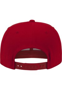 Rode snapback pet met een effen stofontwerp, voorzien van een gebogen klep en een verstelbare plastic strap aan de achterkant.