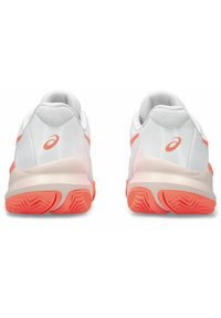 Zapatillas deportivas blancas con parte superior de malla, acentos en rosa claro y una suela texturizada con un patrón en zigzag.