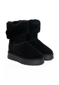 Botines de ante negro con un puño de piel de pelo suave y plegable, puntera redonda y suela de goma texturizada. Superficie lisa con costuras duraderas.