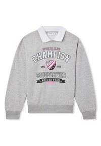 Szary sweter z białym kołnierzykiem, z graficznym nadrukiem, na którym widnieje napis "Champion Supporter Soccer Team" oraz ikona tarczy i piłki nożnej.