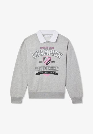 Szary sweter z białym kołnierzykiem, z graficznym nadrukiem, na którym widnieje napis "Champion Supporter Soccer Team" oraz ikona tarczy i piłki nożnej.