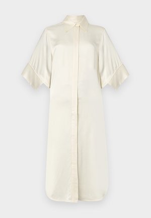 Krémové hedvábné šaty ve stylu košile s klasickým límcem, krátkými širokými rukávy a zapínáním na přední straně, s hladkým a lesklým povrchem.