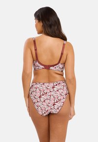 Conjunto de bikini con estampado floral en rojo y rosa. Presenta un top estructurado con tirantes ajustables y una parte inferior alta, confeccionado en una tela suave.