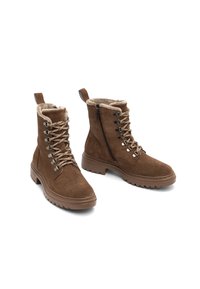 Bottines en suède marron avec lacets beiges, fermeture éclair sur le côté, doublure en peluche et semelles en caoutchouc épaisses sur fond blanc.