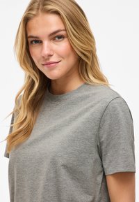 Grå t-shirt med korta ärmar, rund halsringning och mjuk textur, med en enkel design utan synliga mönster eller detaljer.