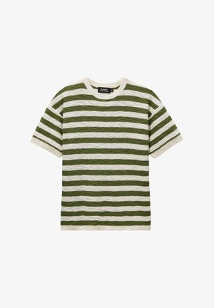 Chemise tricotée à manches courtes avec des rayures horizontales vertes et blanc cassé et un col rond, posée à plat sur fond blanc.