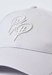 Gorra de béisbol gris con un diseño estructurado, que presenta un logo bordado en blanco. Hecha de un tejido texturizado, con visera curva y ojales de ventilación.