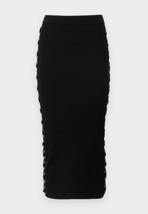 Čierna rebrovaná úzke sukňa s priliehavým strihom. Obsahuje dekoratívne očká a zlaté kovové detaily po stranách.
