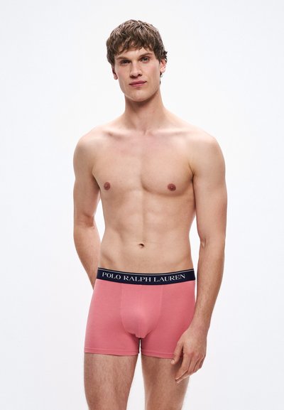 Pánske boxerky z ľahkej ružovej bavlny s tmavomodrým elastickým pásom s nápisom "POLO RALPH LAUREN". Hladká textúra, priliehavý strih.