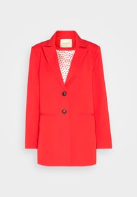 Blazer rouge vif pour femmes avec deux boutons noirs, col à revers et doublure blanche avec des pois rouges sur un fond uni.