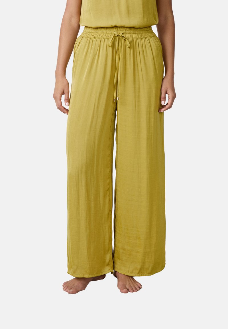 Pantalones de pierna ancha en suave tejido texturizado color mostaza, con cintura elástica y detalle de cordón, que cuentan con bolsillos laterales para mayor funcionalidad.