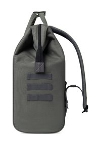 Sac à dos gris à rabat fabriqué en tissu durable, avec une surface texturée, des bretelles réglables et trois boucles de sangle horizontales à l'avant.