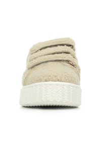 Scarpa slip-on beige con texture pelucida, tre cinturini regolabili e una suola bianca texturizzata. Design semplice e arrotondato. Nessun marchio visibile.