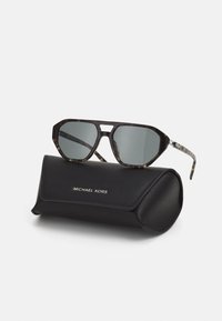 Želvovinové sluneční brýle se šedými skly, ostrý rám a elegantní černé pouzdro s kovovým logem "MICHAEL KORS".