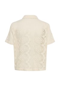 Krämfärgad spetsblus med krage, korta ärmar och intrikata blommönster över hela tyget. Strukturerad, lätt design.