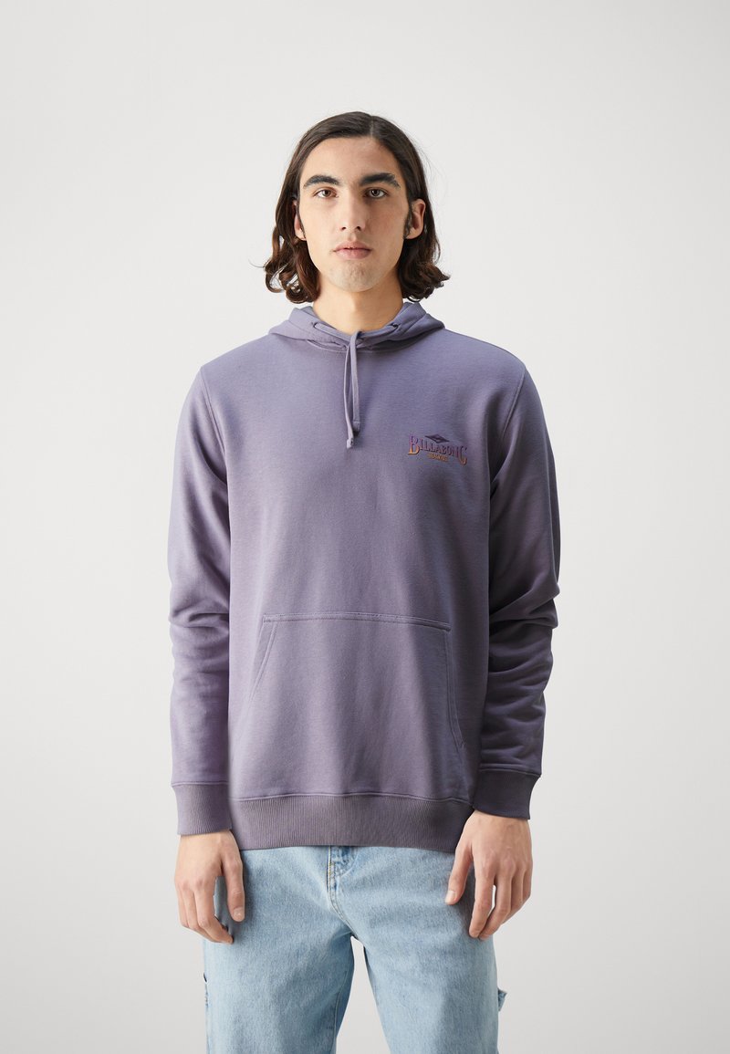 Fialová mikina vyrobená z mäkkého materiálu, so prednou kapsou, kapucňou na šnúrku a vyšitým logom na hrudi. Preklápajúce sa švy.