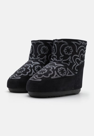 Black suede ankle boots featuring intricate white floral embroidery, rounded toe, and textured rubber sole for grip.