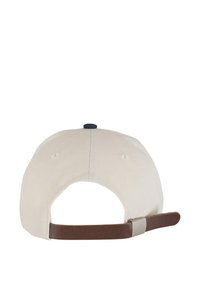 Beige baseball sapka, barna állítható pánttal és kék gombbal a tetején. Sima anyag, varrt szellőzőnyílásokkal.