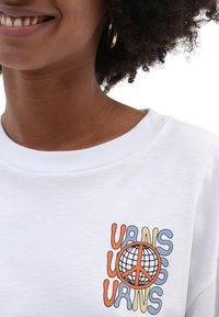 Weißes Sweatshirt mit einem Frontlogo, das den bunten Text "VANS" in Orange, Blau und Gelb darstellt, neben einem Design mit dem Friedenssymbol.
