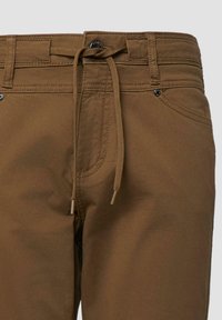 Pantalon marron avec passants de ceinture, poches avant, fermeture à bouton et un cordon marron assorti noué à la taille.